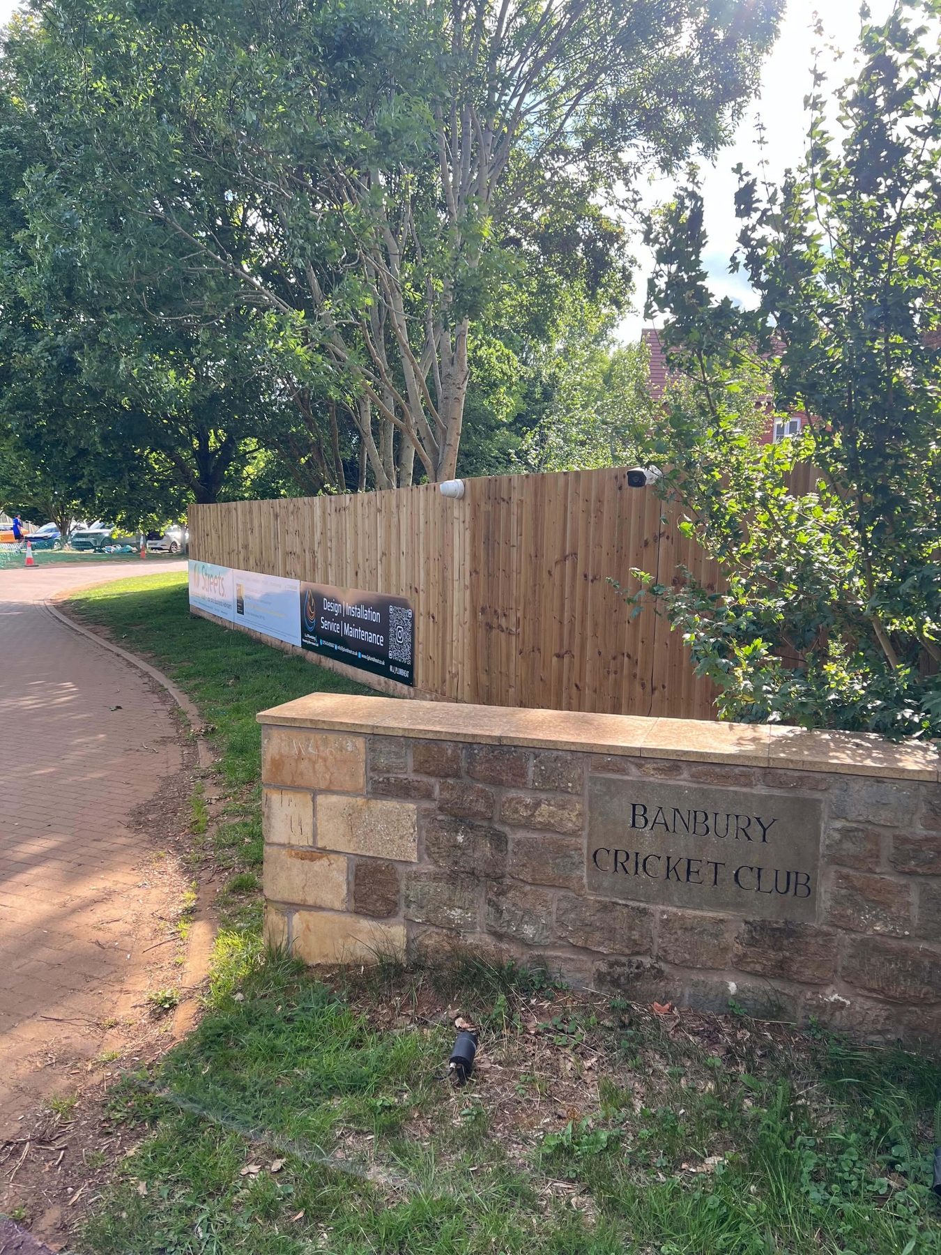 Banbury Cricket Club entrance with the company banner on the fence