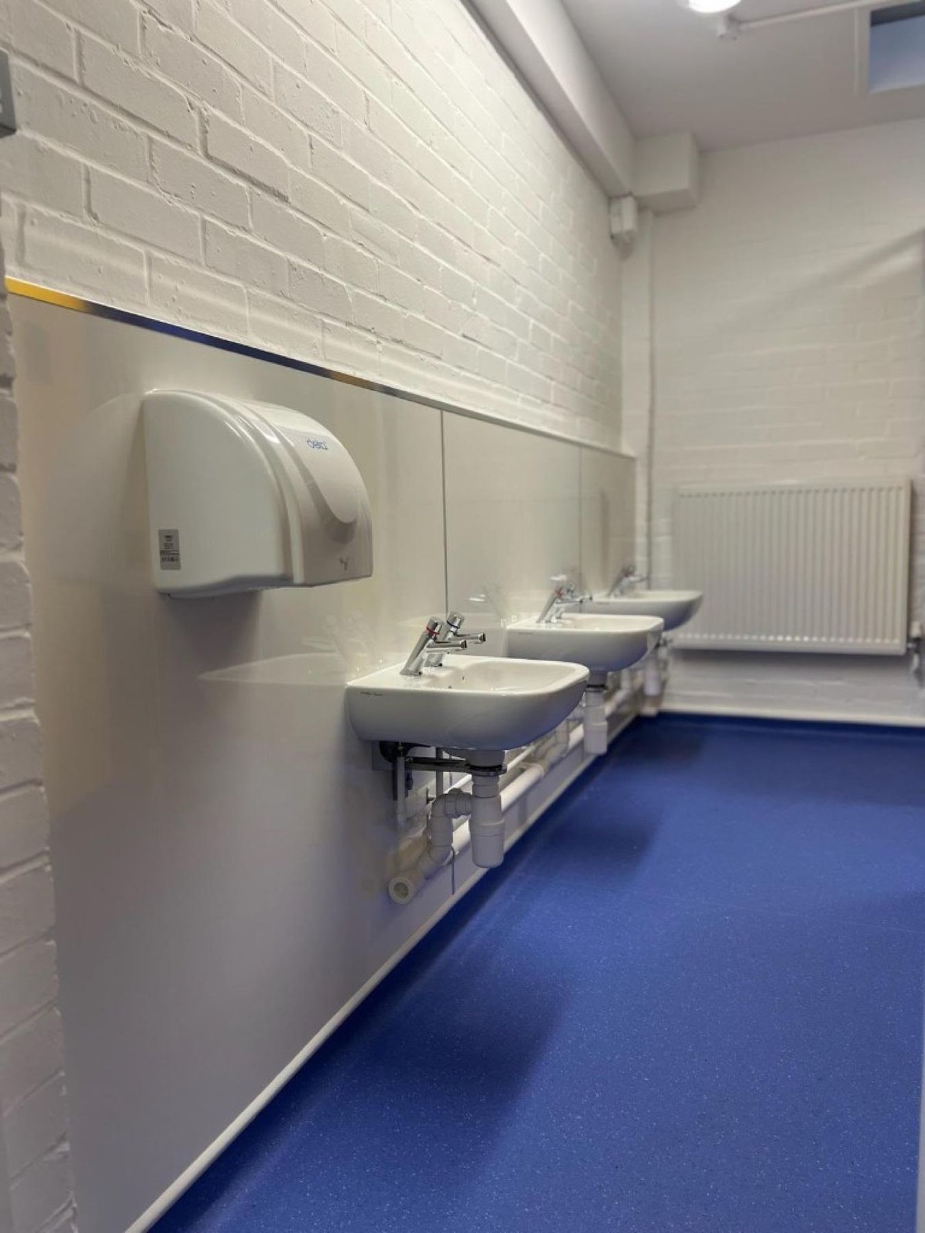 Relocated washbasins with self-closing taps